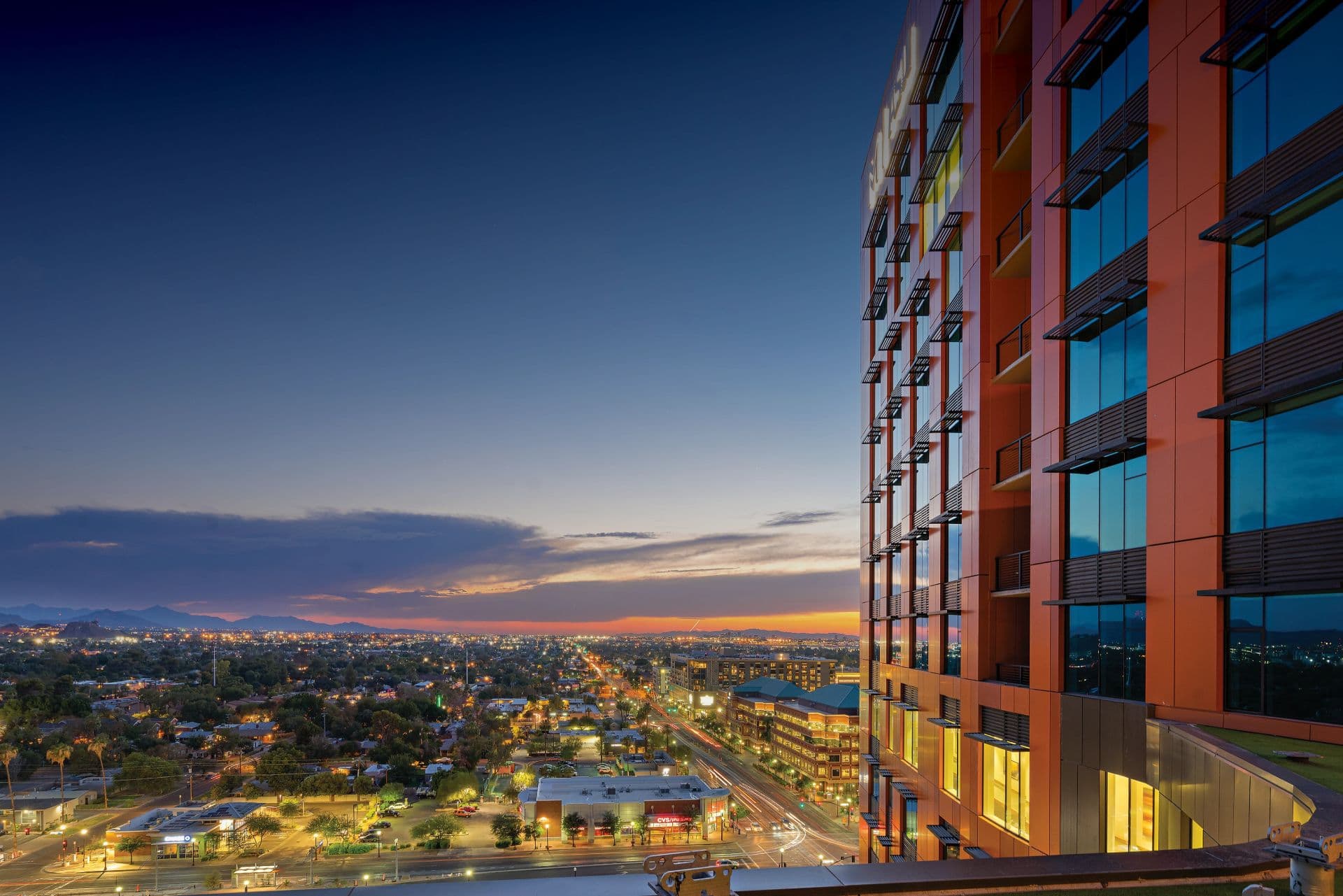 An aerial view of the side of the Mirabella at ASU building and the Tempe skyline.