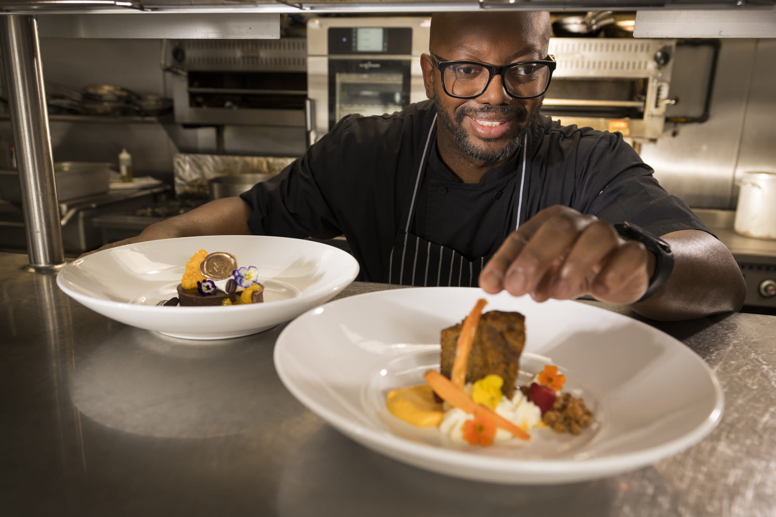 A Mirabella at ASU chef finishes a dish with a gourmet garnish.